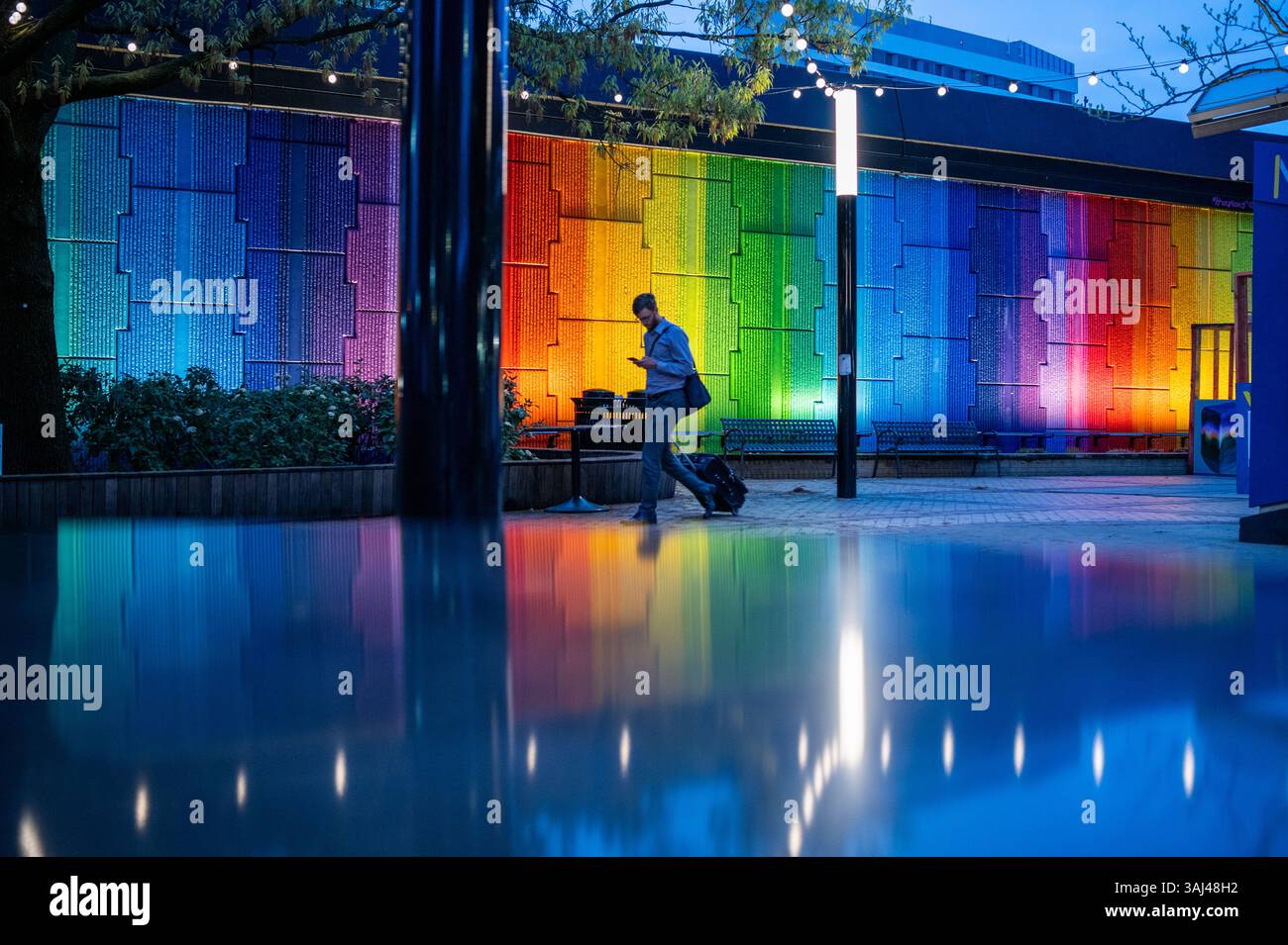 Harmony mural Crystal City Metro Station Arlington Virginie // ARLINGTON, Virginie — la fresque Harmony, une œuvre d'art dynamique à 23 couleurs de l'artiste Lisa Marie Thalhammer, est illuminée à la Crystal City Metro Station plaza. Achevée en 2021, cette peinture murale en émail pulvérisé de 35 mètres (115 pieds) sur 6,1 mètres (20 pieds) sur béton a été commandée par le National Landing Business Improvement District. L'œuvre offre des avantages thérapeutiques aux navetteurs et sert de point de repère pour la transformation de Crystal City en National Landing. Sa création a utilisé un public-privé réussi Banque D'Images