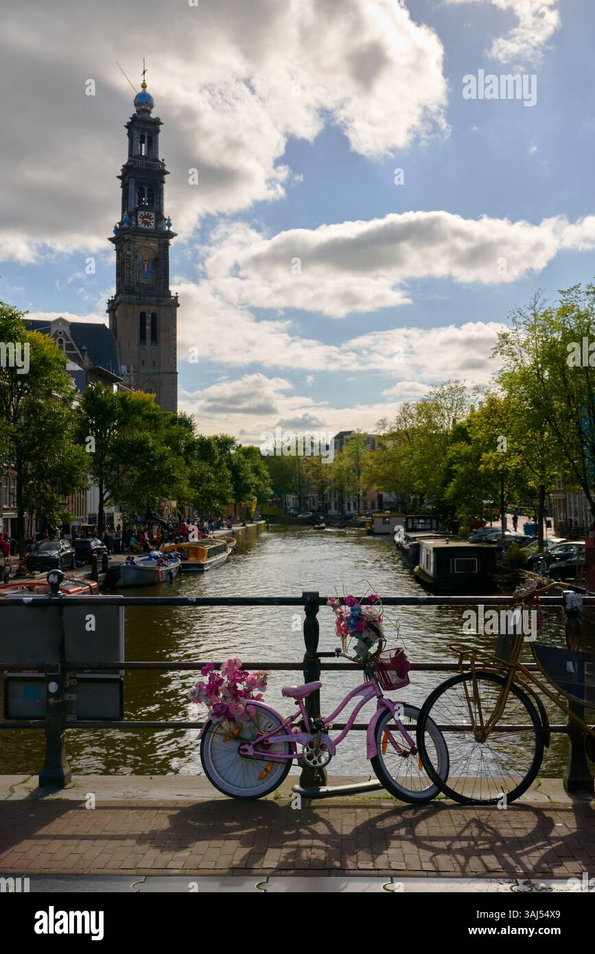 Vélo rose sur un Prinsengracht canal Bridge Amsterdam. Vélos sur un pont sur le canal Prinsengracht avec la tour de l'église Westerkerk. Banque D'Images