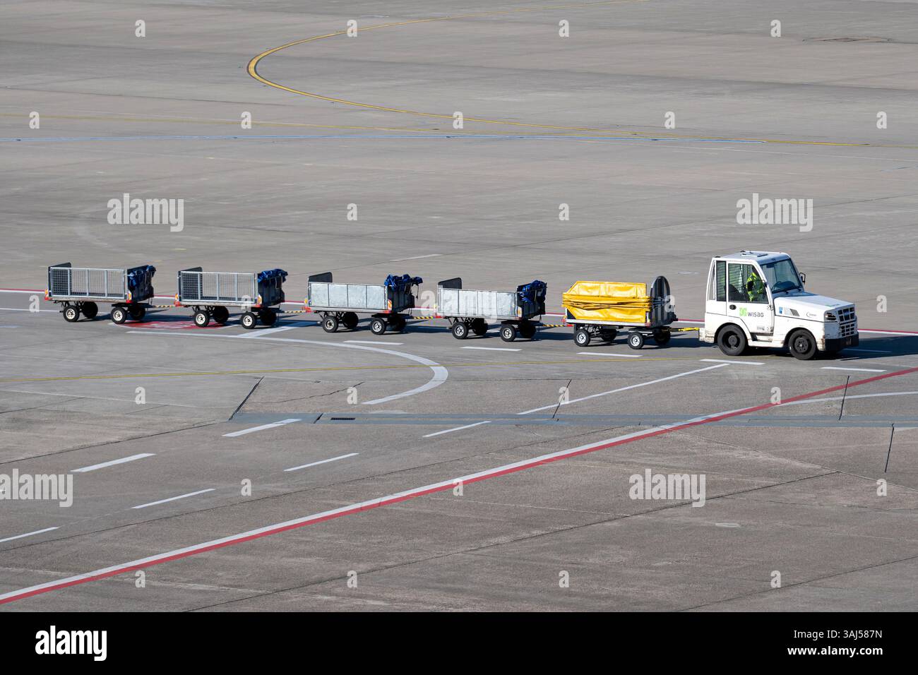 Tracteur WISAG tirant des chariots à bagages vides à l'aéroport de Cologne Bonn Banque D'Images