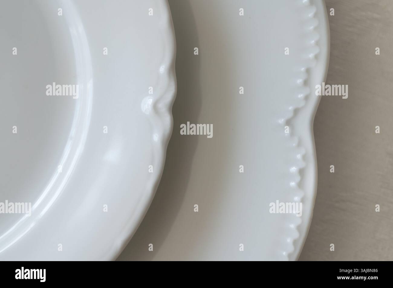 Détail de bord de plaques de porcelaine blanche sur une nappe blanche Banque D'Images