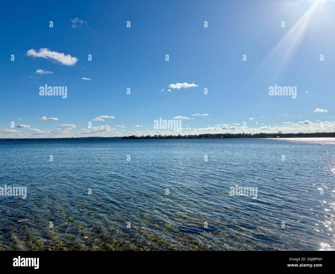 Crystal Clear Lake Water sous Blue Sky - Image de stock capturée avec un smartphone