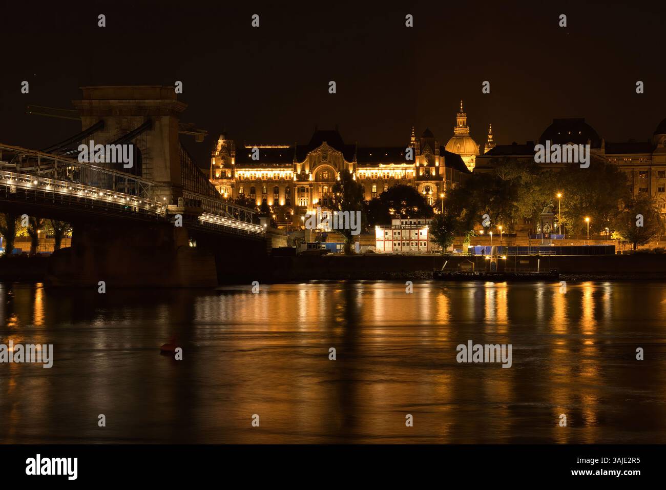 Budapest, Hongrie - 25 octobre 2021 : le pont des chaînes Széchenyi sur le Danube menant au palais de Gresham par une nuit d'été sombre en Hongrie. Banque D'Images