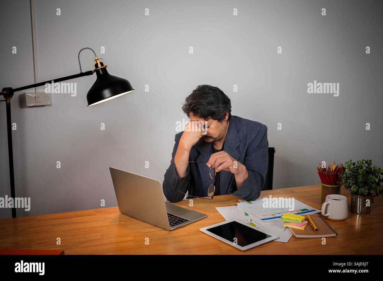 Un jeune homme fatigué ressent une douleur oculaire tenant des lunettes frottant des yeux secs irrités fatigués par le travail informatique, l'homme stressé souffre de mal de tête mauvais visi Banque D'Images