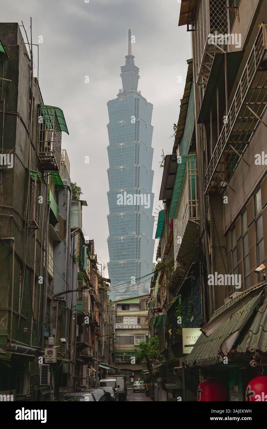 Personne tenant un parapluie violet et Taipei 101 bâtiment dans le fond d'une rue de la ville à Taiwan. Photo prise sur un nuageux sur un jour nuageux Banque D'Images