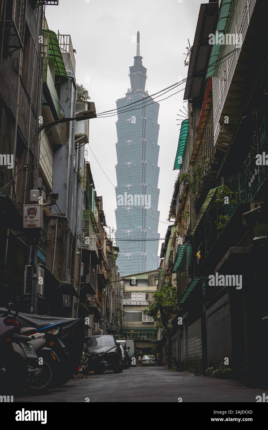 Personne tenant un parapluie violet et Taipei 101 bâtiment dans le fond d'une rue de la ville à Taiwan. Photo prise sur un nuageux sur un jour nuageux Banque D'Images