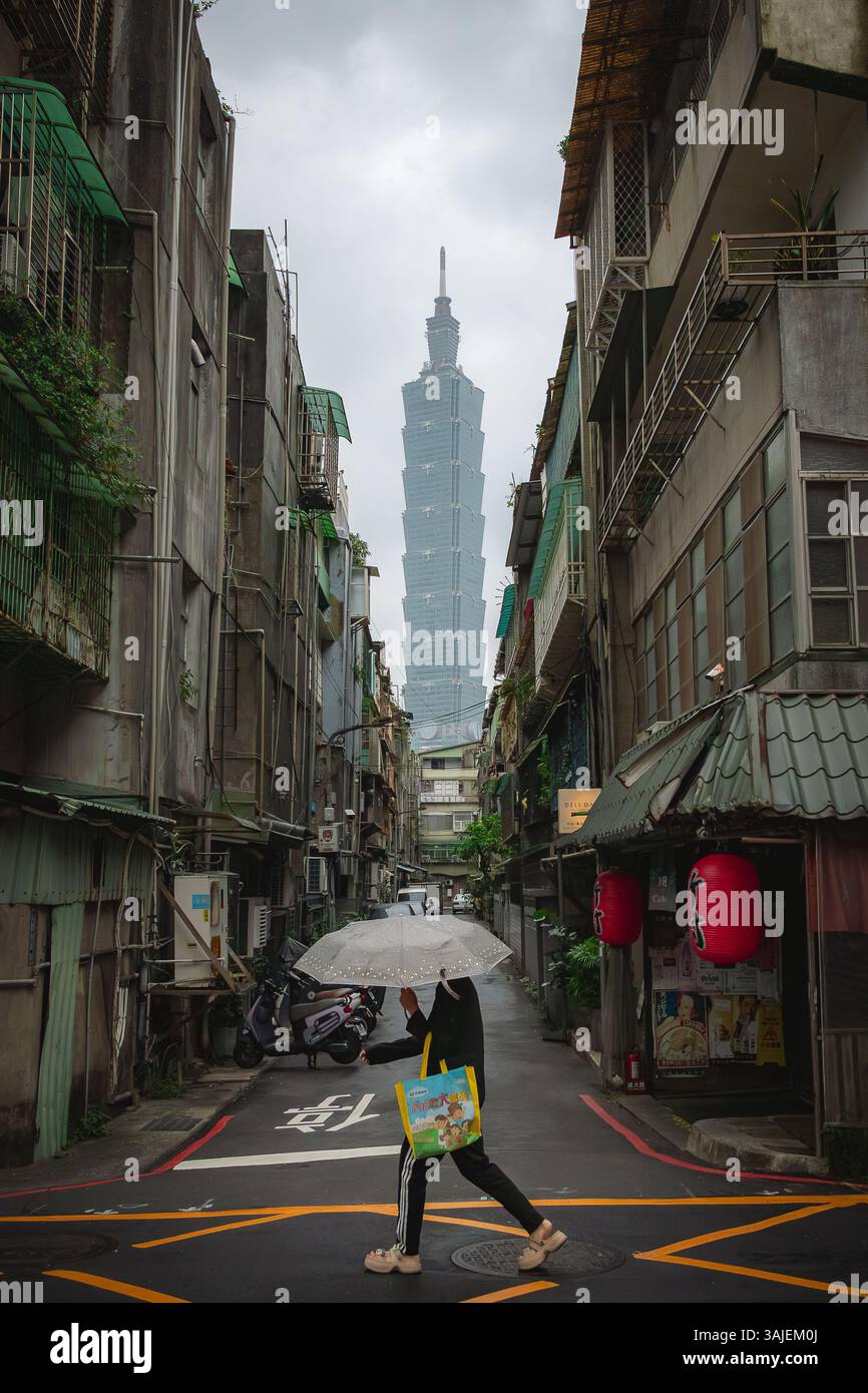 Personne tenant un parapluie violet et Taipei 101 bâtiment dans le fond d'une rue de la ville à Taiwan. Photo prise sur un nuageux sur un jour nuageux Banque D'Images