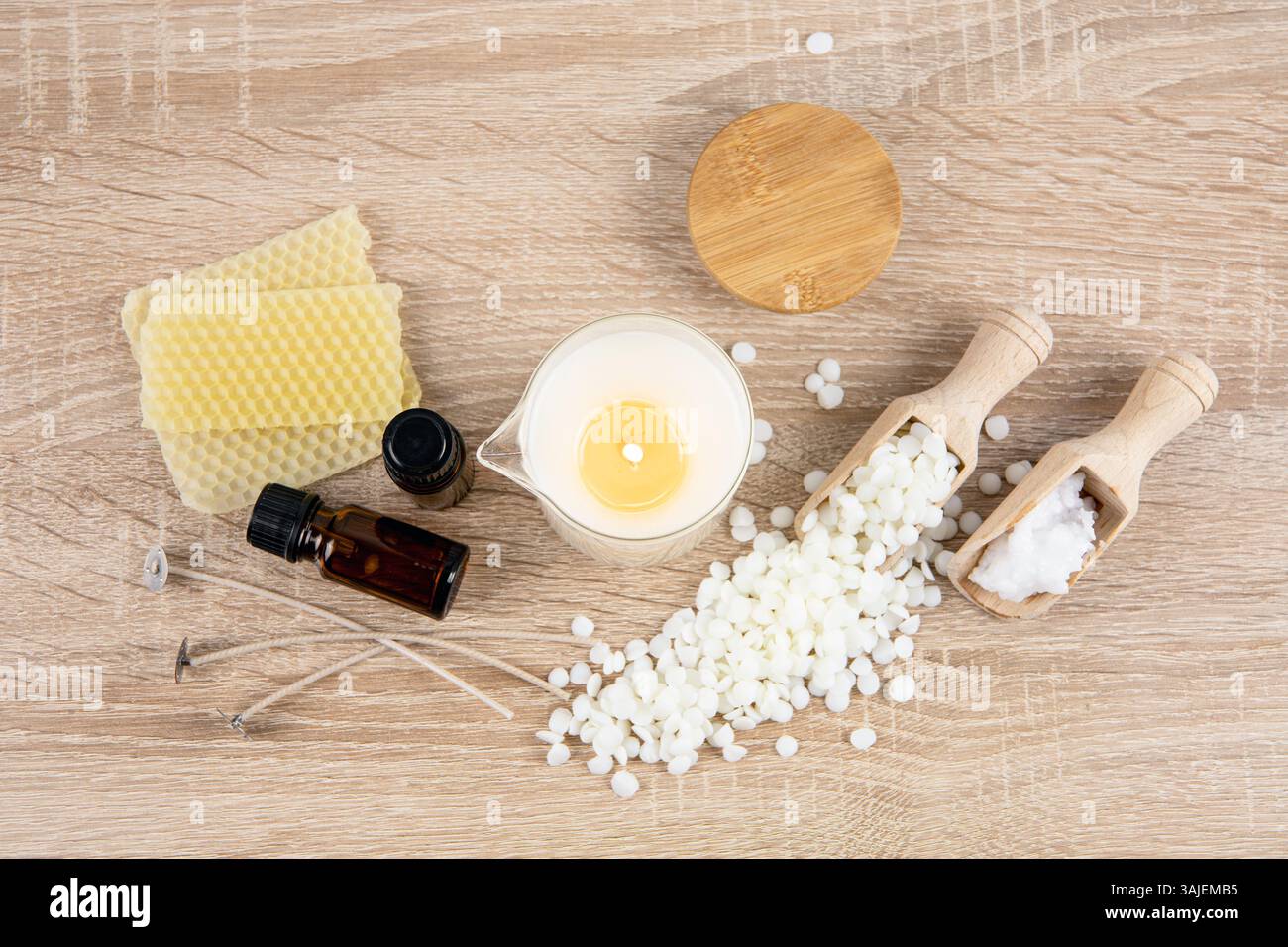 Concept de fabrication de bougie d'huile de massage maison parfumée. Outils, matériaux sur les bouteilles d'huile de parfum de table, pot en verre avec bec verseur, cire de noix de coco. Banque D'Images