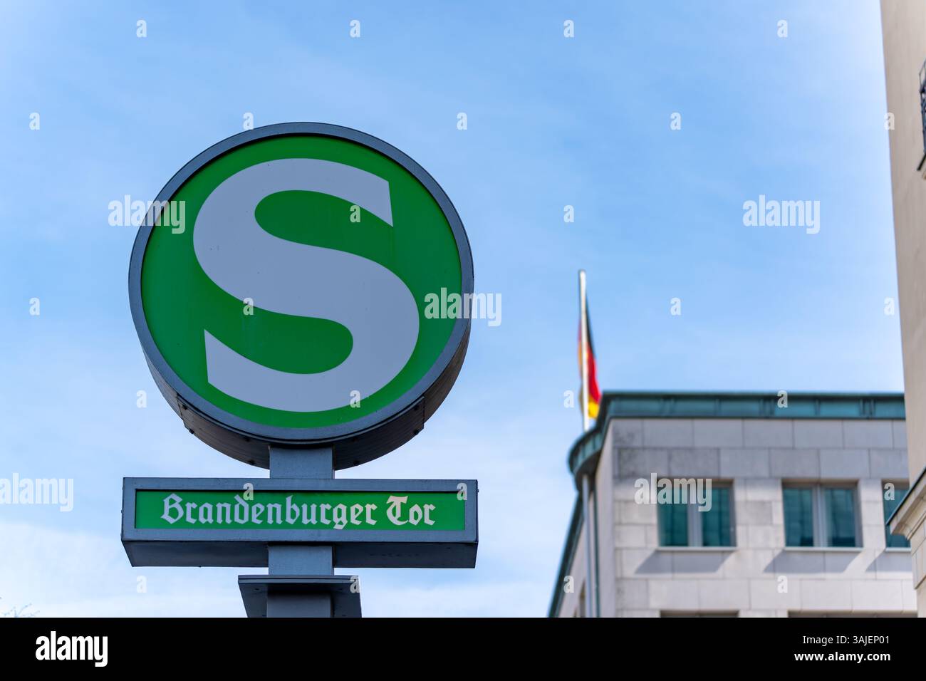En arrière-plan, un panneau vert indique l'arrêt du S-Bahn à la porte de Brandebourg. Gros plan du symbole S-Bahn. Banque D'Images