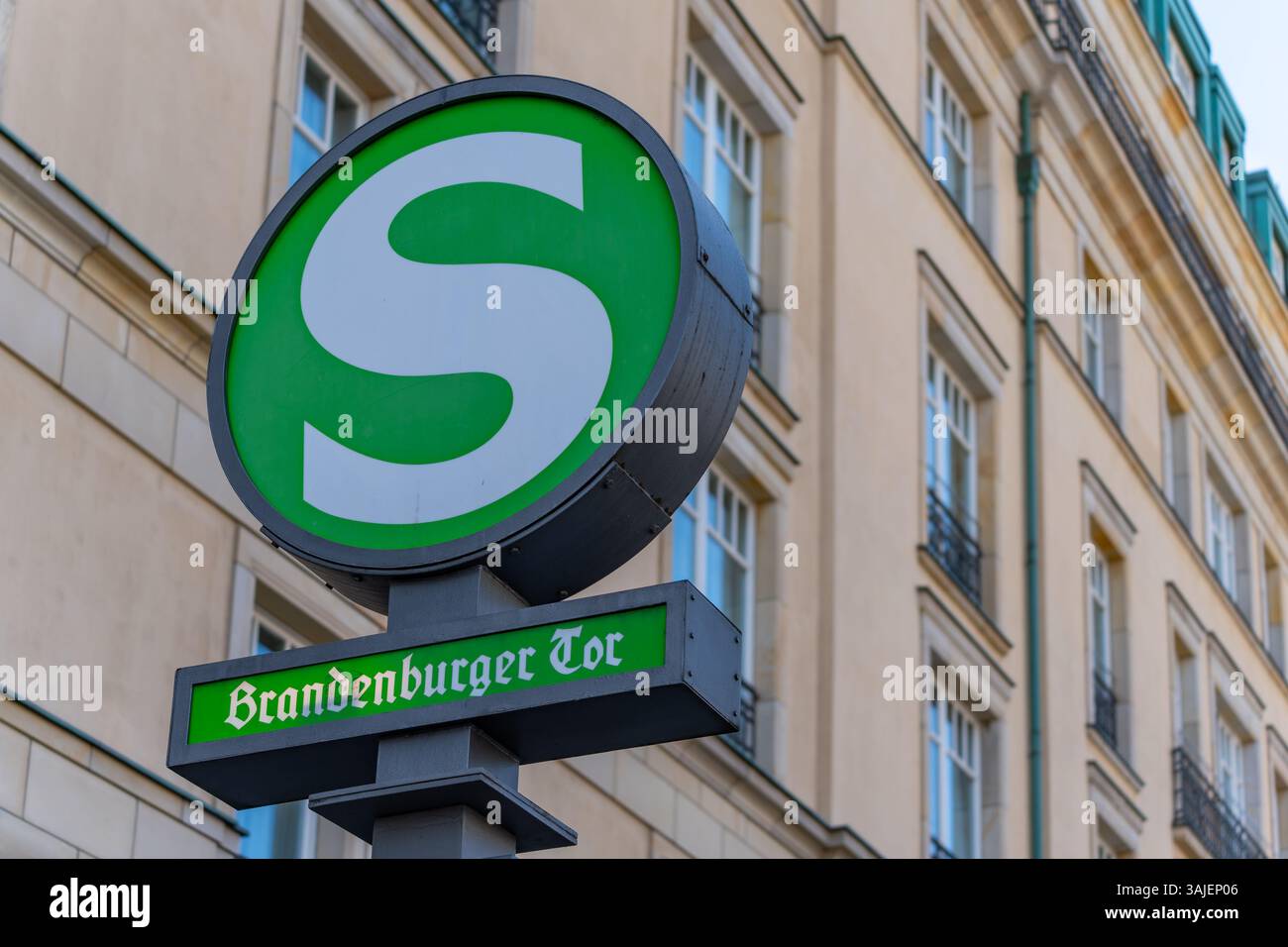 En arrière-plan, un panneau vert indique l'arrêt du S-Bahn à la porte de Brandebourg. Gros plan du symbole S-Bahn. Banque D'Images