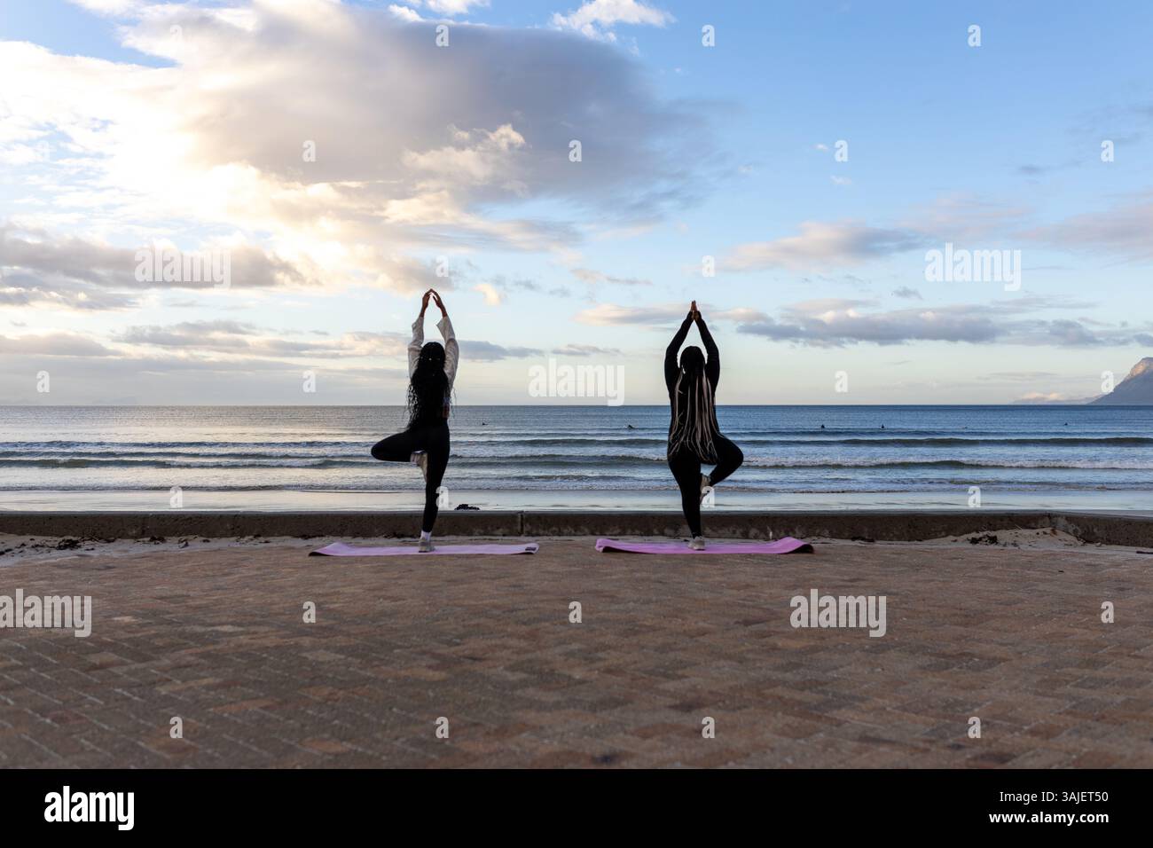 Pose de yoga au lever du soleil à l'océan Banque D'Images