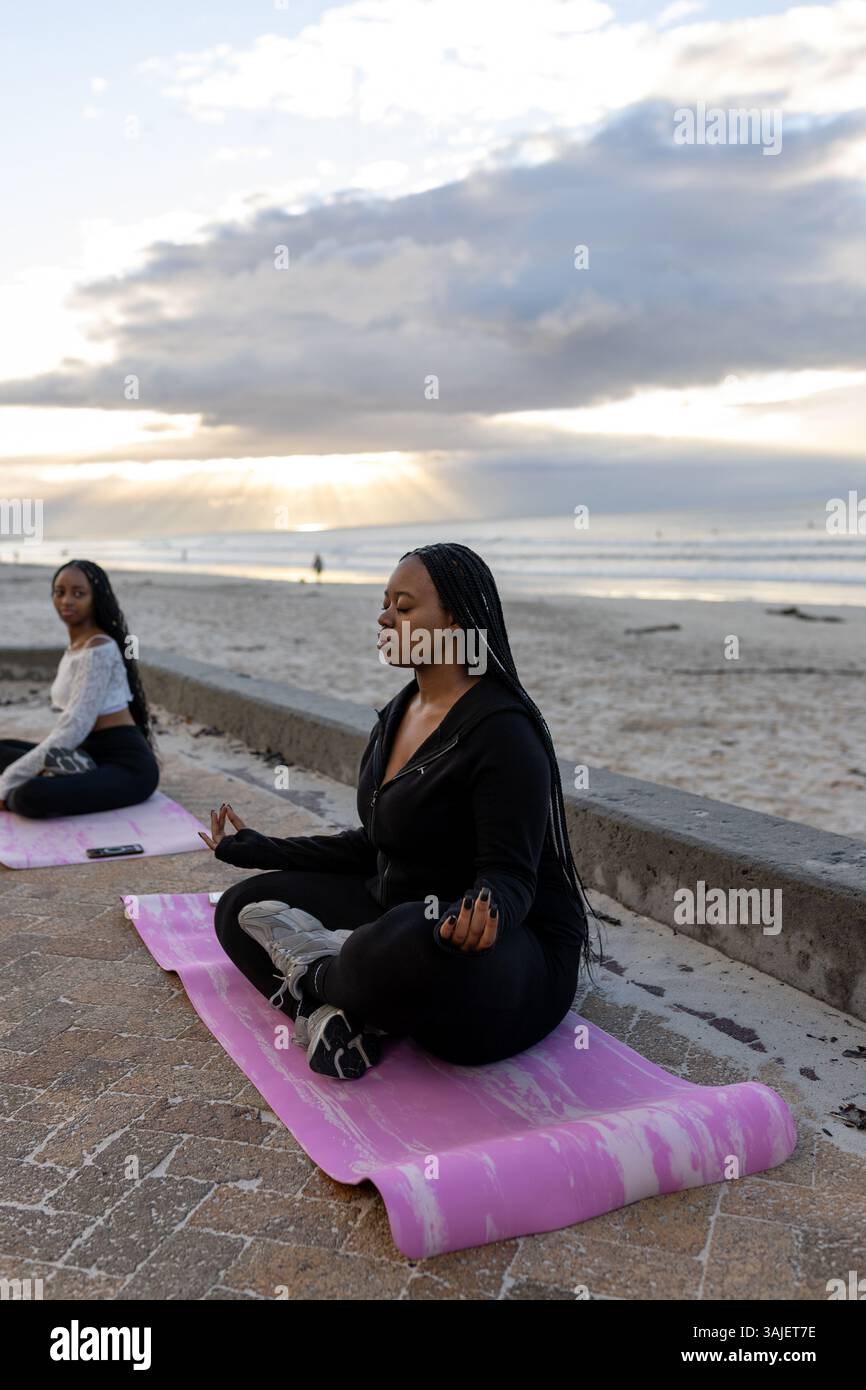 Méditation de plage au lever du soleil et vêtements de yoga athlétiques Banque D'Images