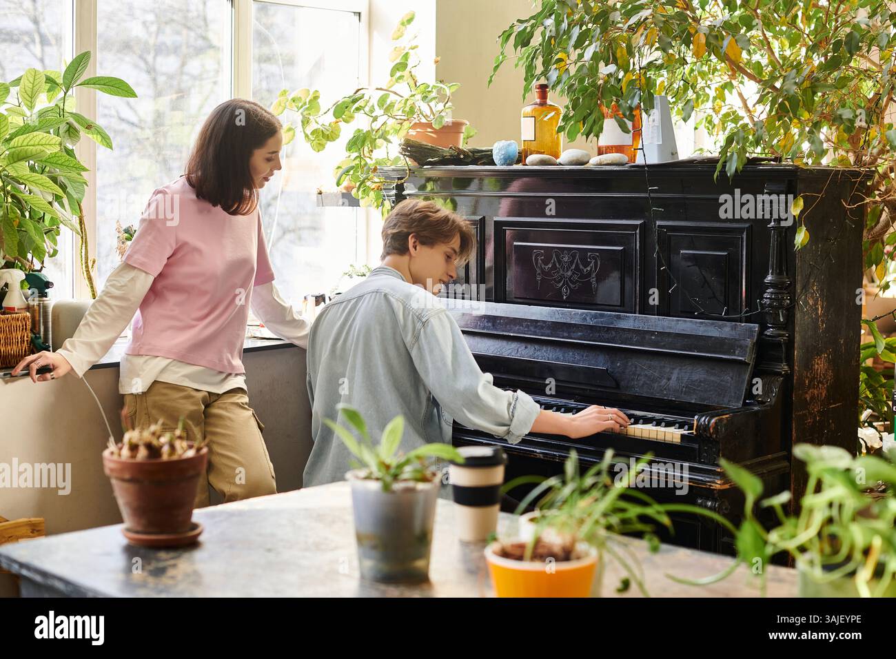 Couple aimant partager un moment dans un studio d'art animé, entouré de verdure et d'énergie créative. Banque D'Images