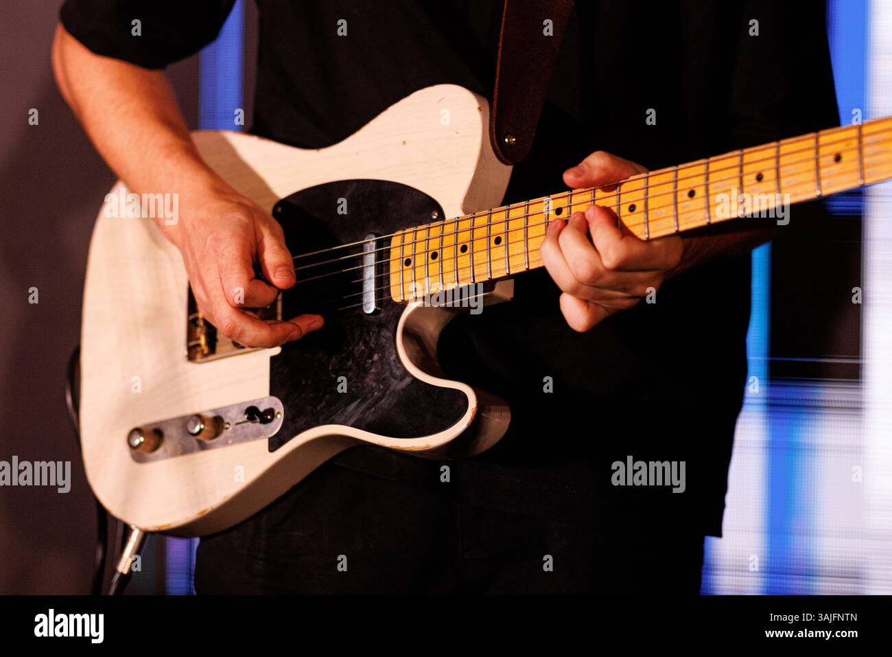 Les mains jouent habilement une guitare électrique, en se concentrant sur les mouvements des doigts et les cordes. Le musicien capture un moment de concentration intense et de musica Banque D'Images