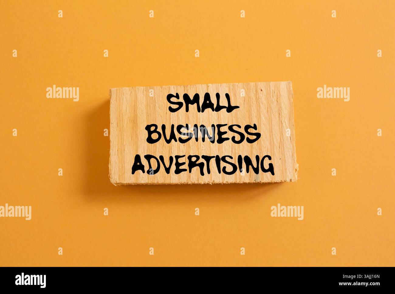 Message publicitaire de petite entreprise écrit sur morceau de bois sur fond orange. Symbole publicitaire conceptuel de petite entreprise. Copier l'espace. Banque D'Images