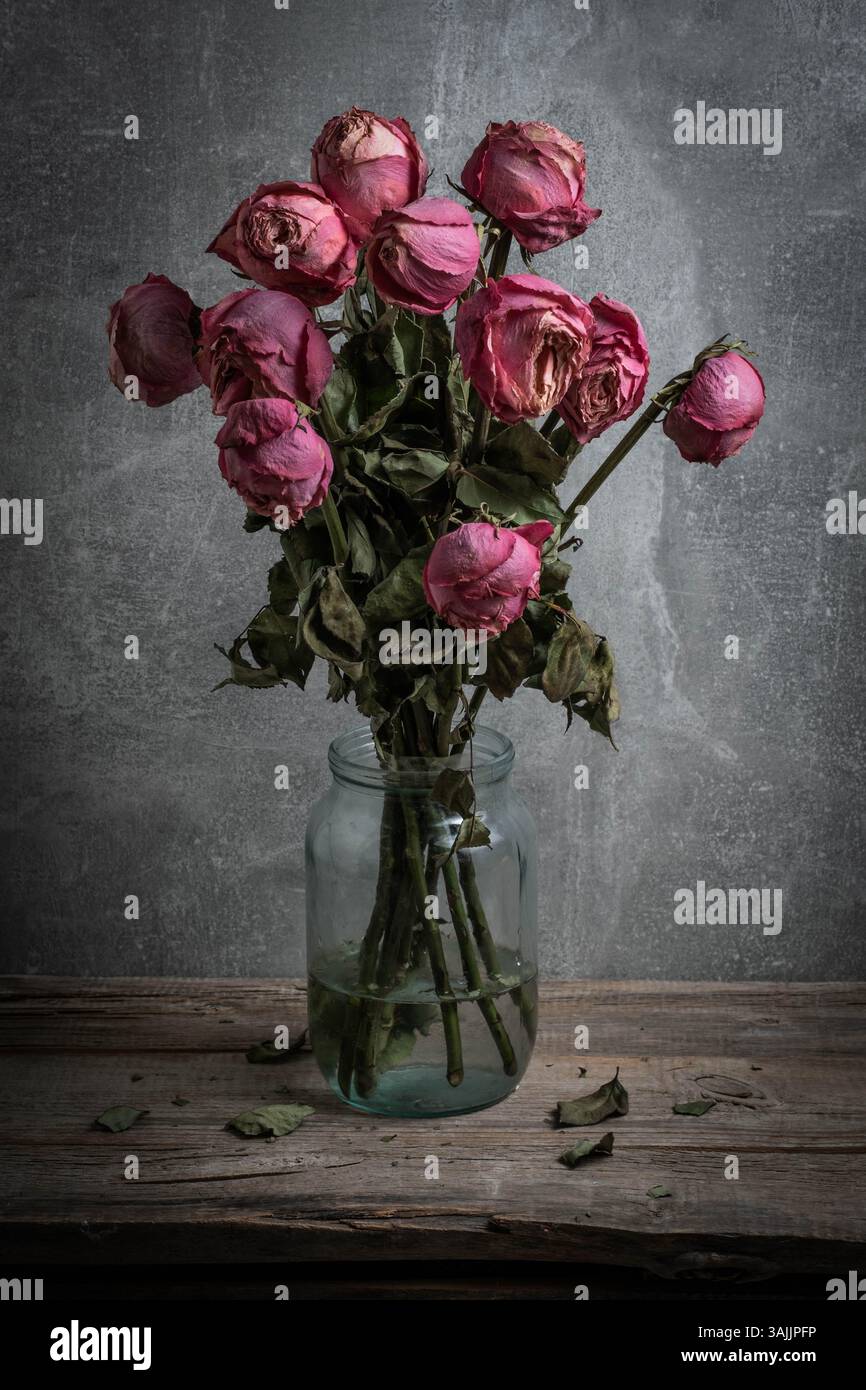 Bouquet de roses séchées dans un bocal en verre sur une table en bois Banque D'Images