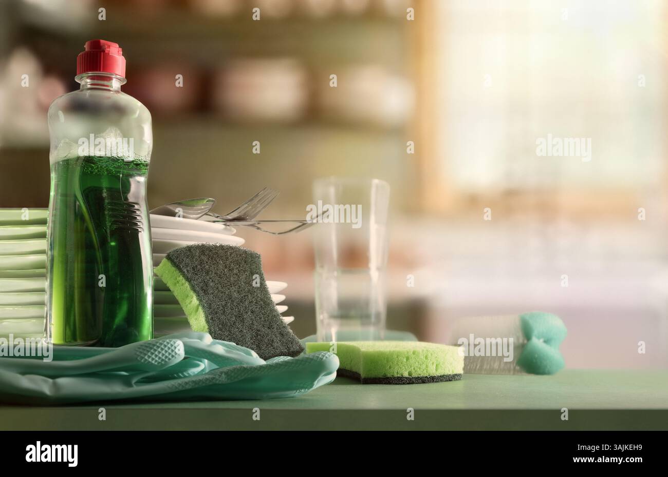 Concept traditionnel de lavage de vaisselle avec des produits sur une table de cuisine verte avec des assiettes et des verres avec fond de cuisine rustique. Vue de face. Banque D'Images