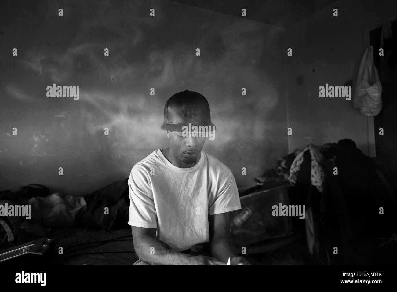 20 avril 2014 - Brooklyn, New York, États-Unis - Smokey allume une cigarette de marijuana tout en s'asseyant dans sa chambre au Bushwick Housing Projects, Smokey est le chef de la tribu South-Side des gangs Latin Kings à Brooklyn et il essaie d'empêcher son peuple de fumer autre chose qui n'est pas de la marijuana parce qu'il veut qu'ils puissent protéger la hotte à tout moment. La toute-puissante Nation latine Roi et Reine (ALKQN, ALKN, LKN) est le plus ancien et le plus grand gang de rue hispanique des États-Unis. Ses racines datent de 1954 Humboldt Park à Chicago, Illinois. (Crédit image : © Nicolas Enriquez/ZUMA Wir Banque D'Images