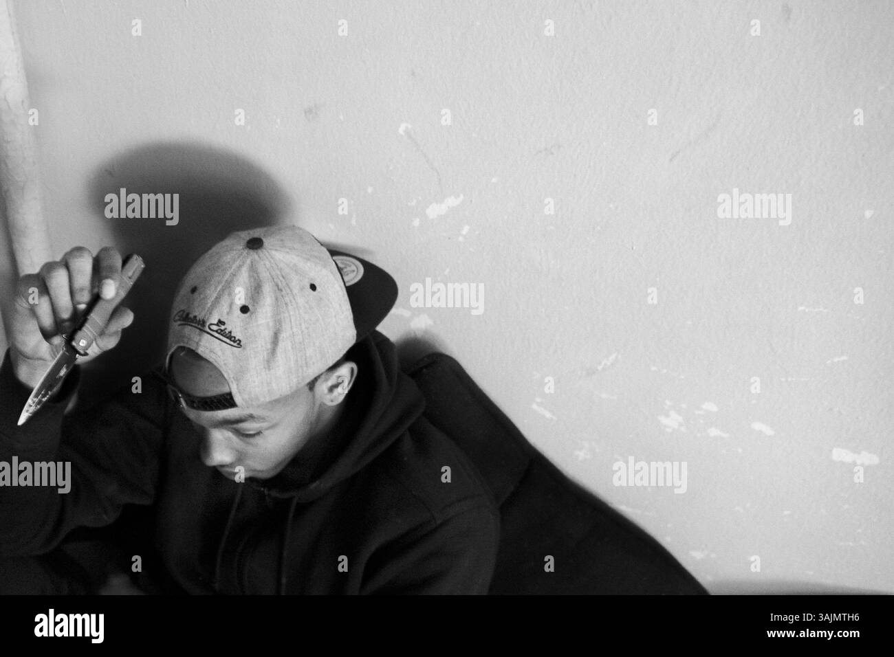 20 avril 2014 - Brooklyn, New York, États-Unis - B-Rad se cache dans le coin de son appartement parce que des policiers et des membres d'un gang ennemi le recherchaient, il faisait partie d'une fusillade au deuxième étage de son immeuble, pendant la fusillade, il a été abattu à la jambe et maintenant il ne peut pas quitter sa maison à cause des représailles du gang. La toute-puissante Nation latine Roi et Reine (ALKQN, ALKN, LKN) est le plus ancien et le plus grand gang de rue hispanique des États-Unis. Ses racines datent de 1954 Humboldt Park à Chicago, Illinois. (Crédit image : © Nicolas Enriquez/ZUMA Wire/ZUMAPRESS.com) Banque D'Images