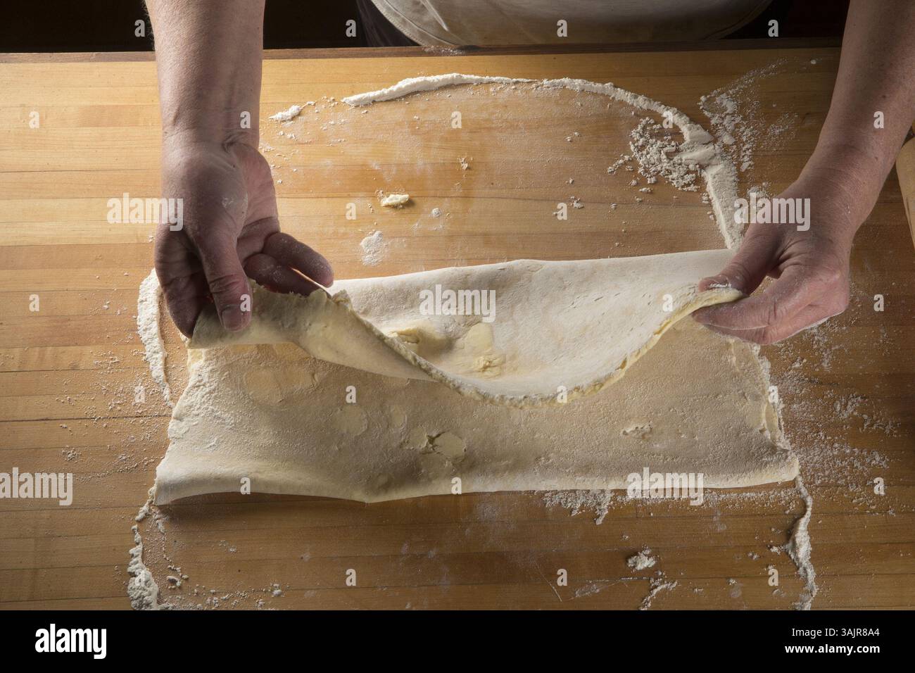 1er juin 2017 - Edina, MN, USA - brossez l'excès de farine de la pâte, puis repliez le tiers supérieur. Amenez le tiers inférieur au-dessus de cela, en pliant la pâte comme une lettre. C'est le premier tour. (Crédit image : © Jerry Holt/TNS via ZUMA Wire) Banque D'Images