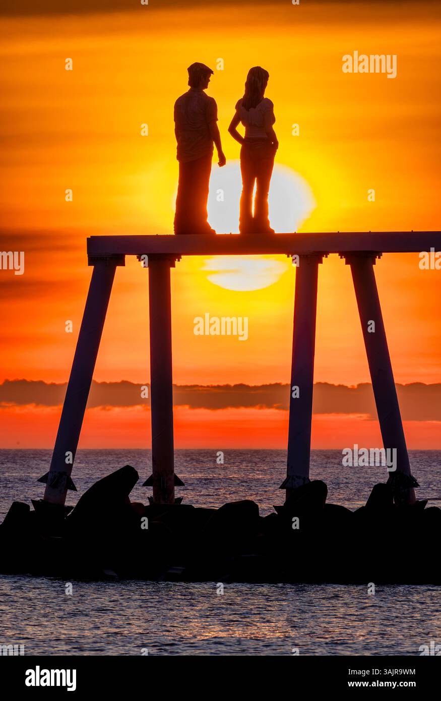 Vue au lever du soleil de la sculpture ''couple'' de Sean Henry à Newbiggin-by-the-Sea dans le Northumberland, au nord-est de l'Angleterre Banque D'Images