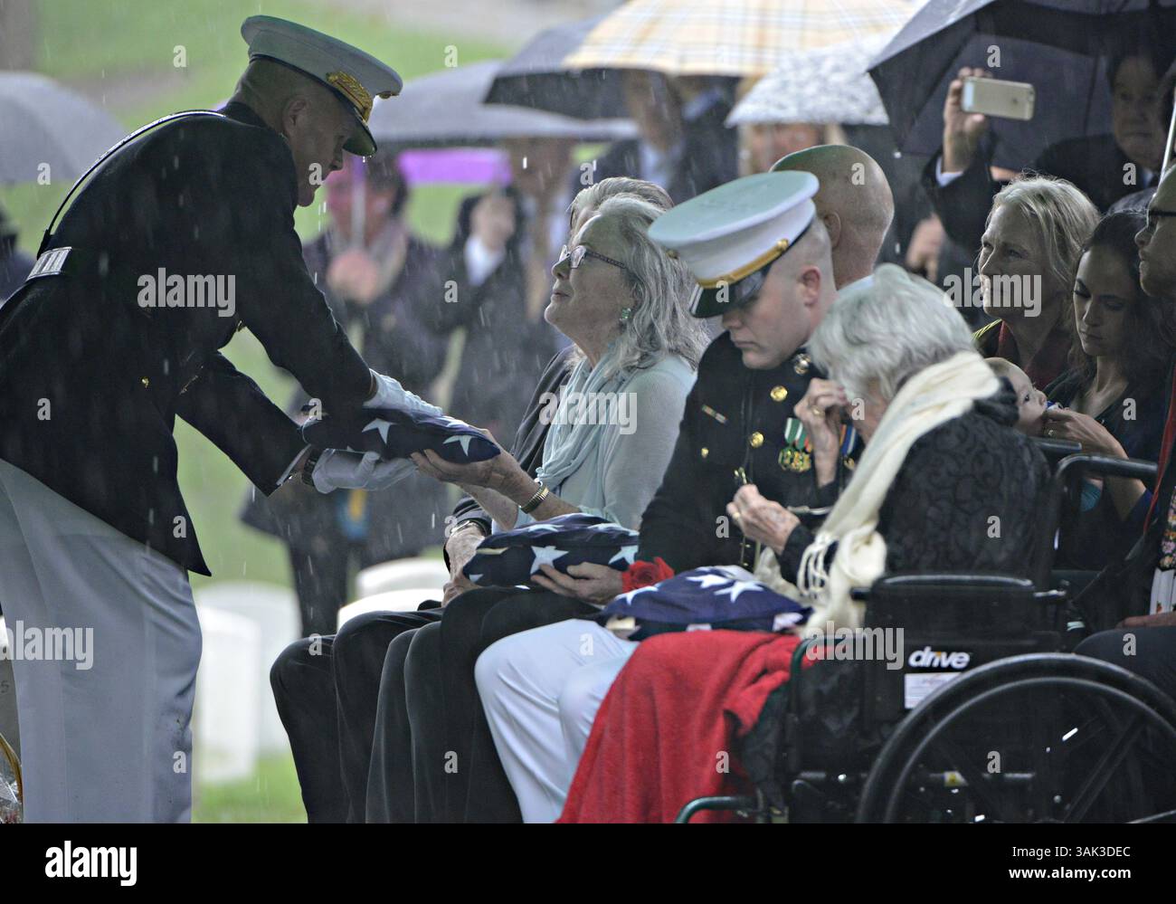 6 avril 2017 - Arlington, Virginie, États-Unis d'Amérique - le commandant du corps des Marines Gen. Robert Neller, à gauche, présente le drapeau américain à Carolyn Glenn, fille de John Glenn alors que la fenêtre Annie Glenn est consolée pendant le service funéraire dans la section 35 du cimetière national d'Arlington le 6 avril 2017 à Arlington, Virginie. Glenn, le premier astronaute américain à orbiter autour de la Terre et plus tard sénateur américain, est décédé à l'âge de 95 ans le 8 décembre 2016. (Crédit image : © Rachel Larue/Planet Pix via ZUMA Wire) Banque D'Images