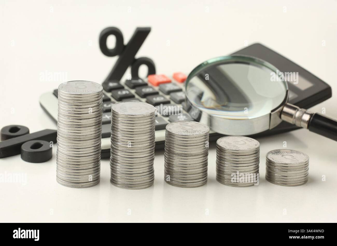 Calculatrice, chtrels, intérêt avec des pièces de monnaie comme graphique à barres sur fond blanc. Concept de crédit, épargne, assurance. Photo de haute qualité Banque D'Images