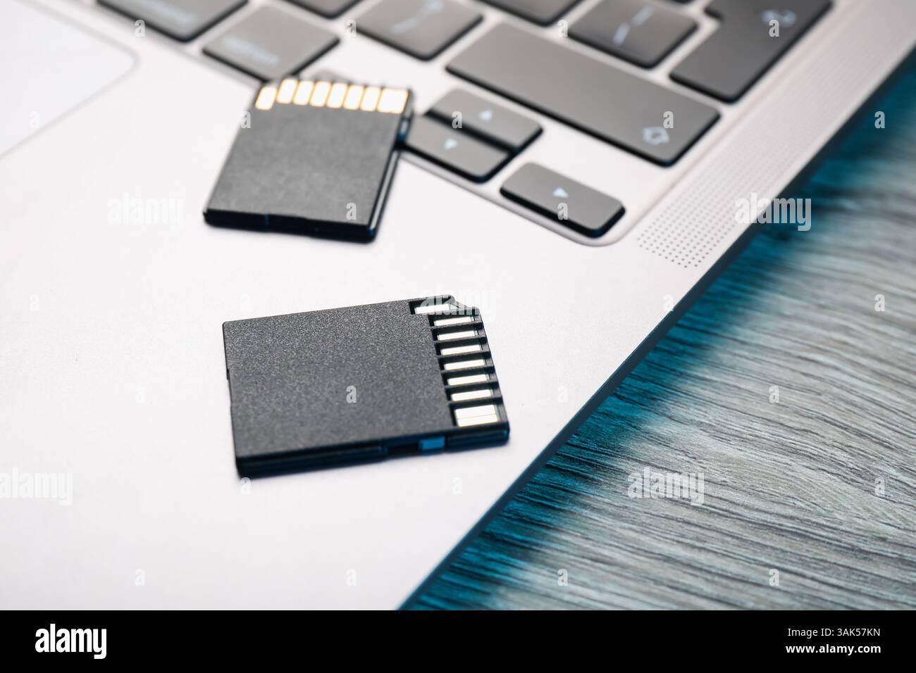 Cartes mémoire SD et ordinateur portable sur table en bois, gros plan Banque D'Images