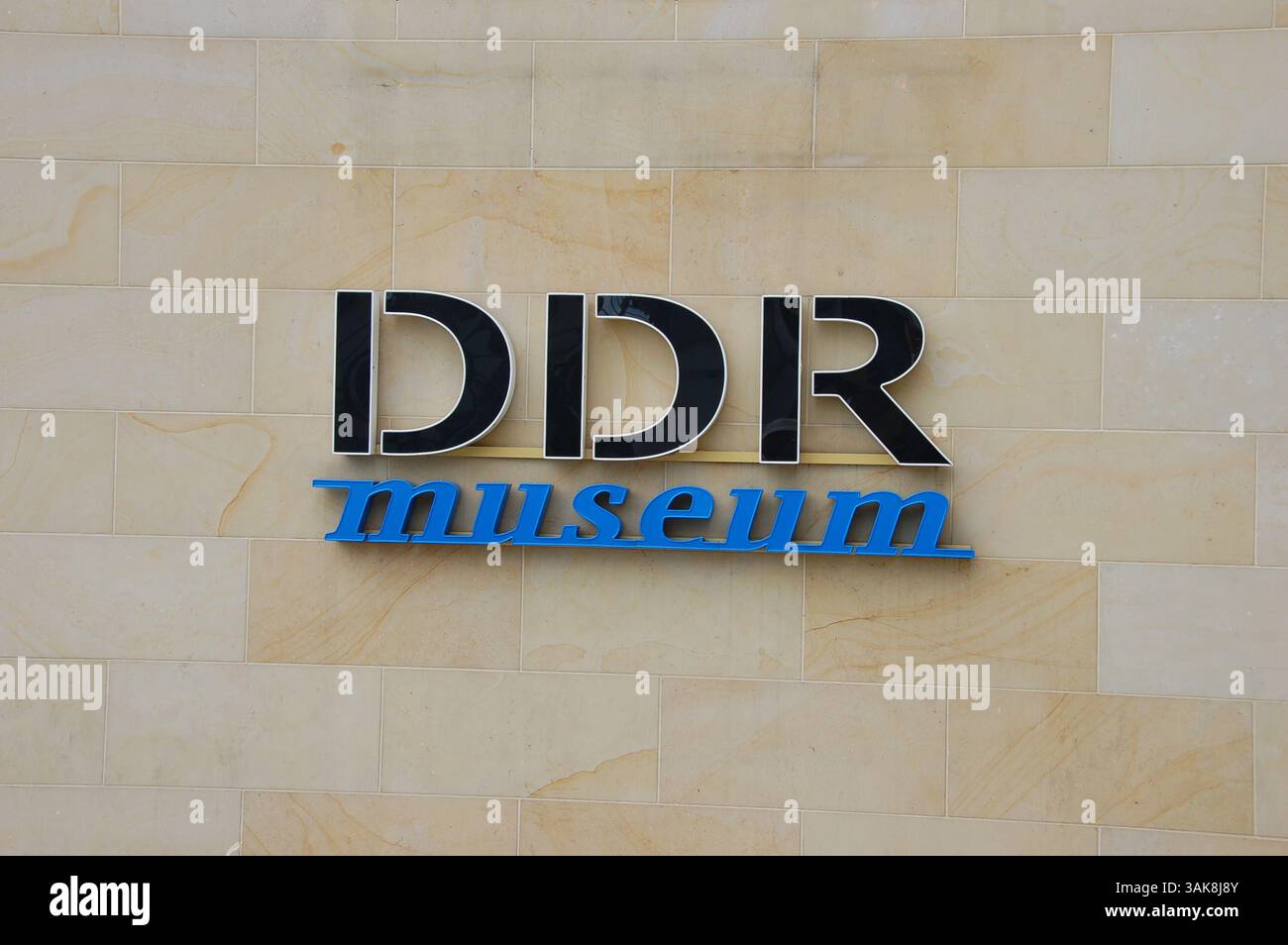 Enseigne du Musée DDR à Berlin, dédiée à la vie quotidienne en Allemagne de l'est à l'époque de la RDA, montée sur un mur de pierre beige Banque D'Images
