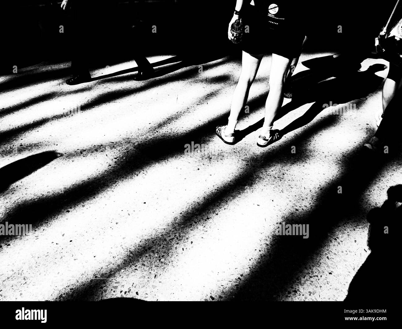 Longues ombres du soir des gens à une gare Banque D'Images