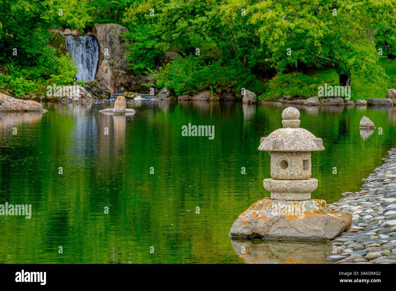 Une cascade et une lanterne en pierre à côté d'un étang tranquille dans le jardin japonais Nikka Yuko à Lethbridge, Alberta Banque D'Images