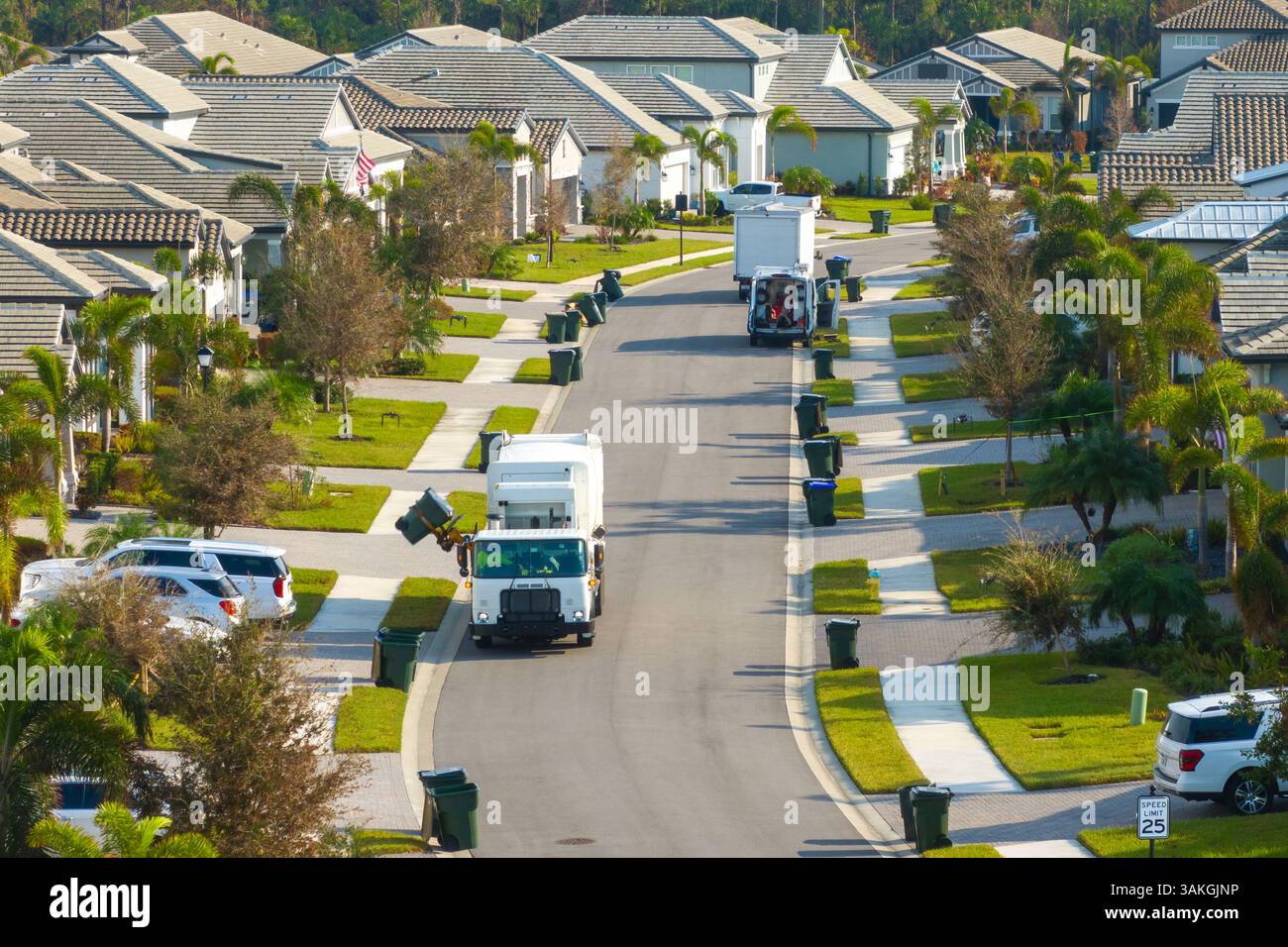 Camion collecteur d'ordures automatisé moderne chargeant les déchets sur la rue de la ville de Floride. Services municipaux Banque D'Images