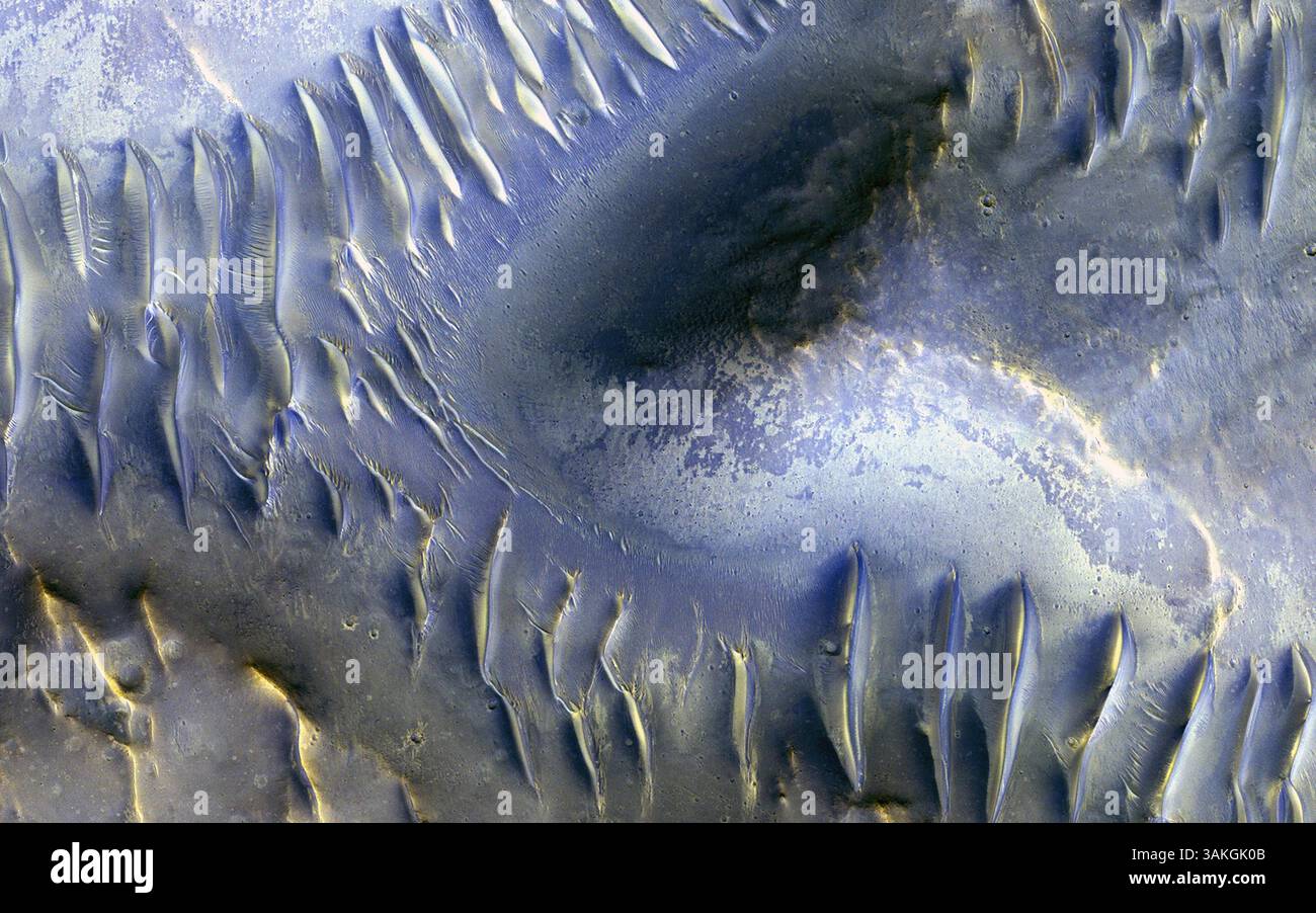 Mars 29, 2017 - mars surface - le monticule au centre de cette image de mars reconnaissance Orbiter (MRO) semble avoir bloqué le chemin des dunes alors qu'elles marchaient vers le sud (le nord est à gauche sur cette image) à travers la scène. Beaucoup de ces dunes transversales ont des glissades qui font face au sud, bien que dans certains cas, c'est difficile à dire avec certitude. Les dunes plus petites courent perpendiculairement à certaines des dunes à plus grande échelle, ce qui indique probablement un changement dans la direction du vent dans cette zone. Bien que cela puisse être difficile à dire, ce groupe de dunes est très près de la fosse centrale d'un cratère d'impact de 35 kilomètres de large. Données fr Banque D'Images