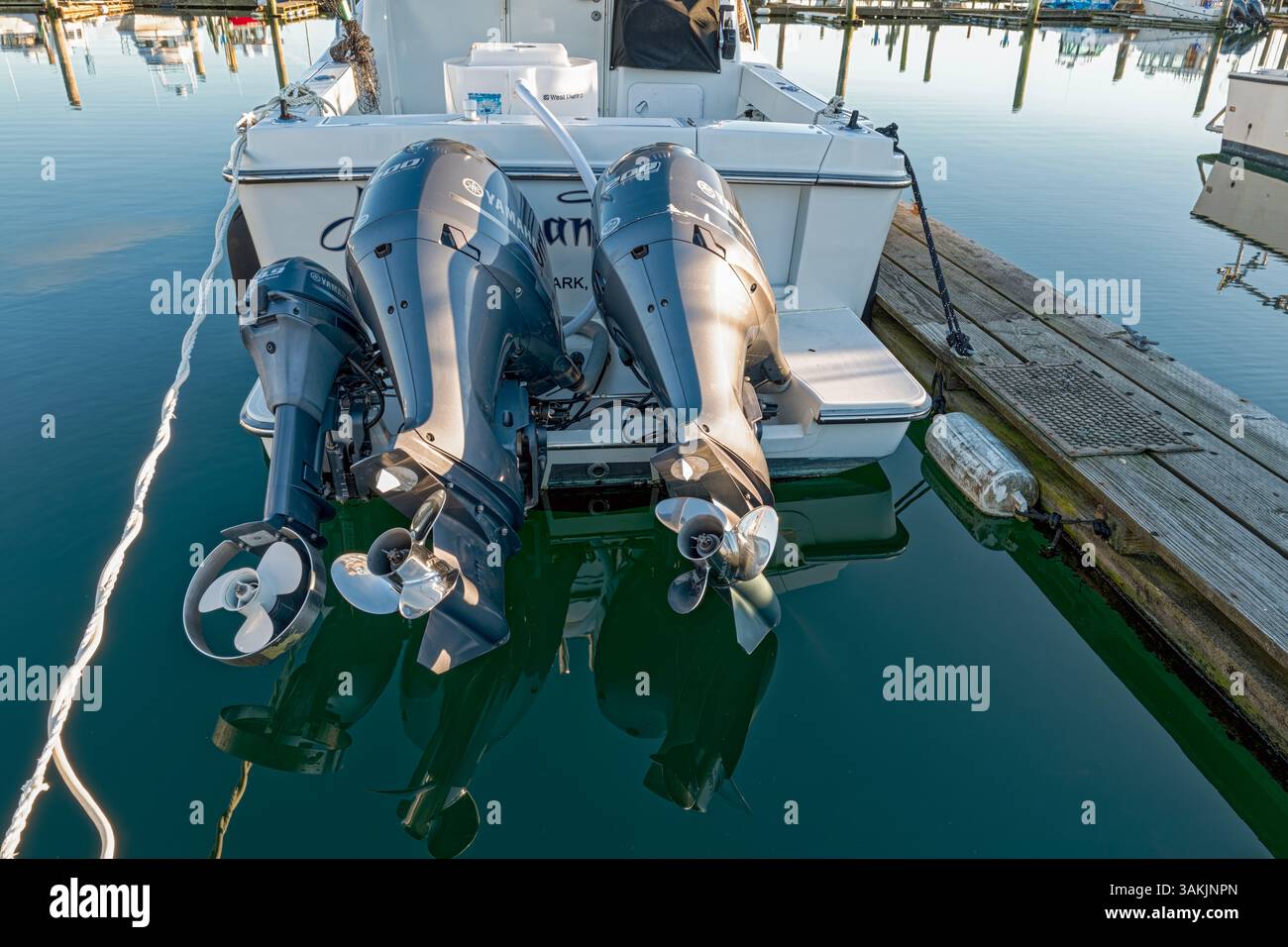 Trois moteurs hors-bord sont installés sur un yacht Ocean Sport Legacy amarré dans le port d'Ilwaco, Washington, États-Unis Banque D'Images