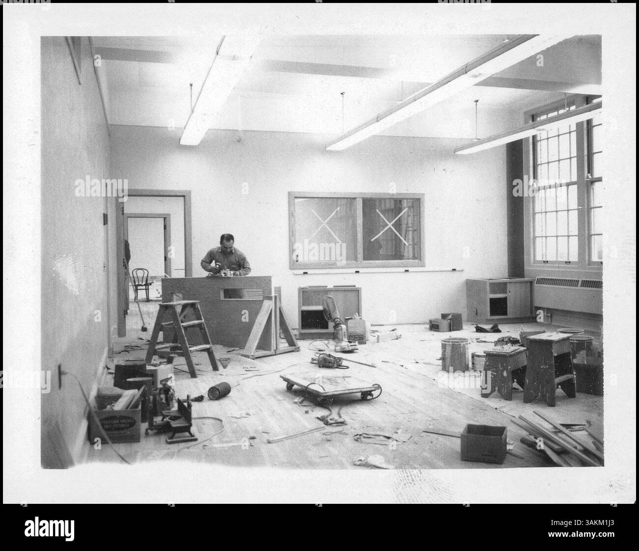 Dans le cadre du programme de construction de l'école secondaire Edison, un travailleur ponce une nouvelle porte. Il met en lumière la modernisation des installations scolaires, en particulier dans des domaines spécialisés comme le département des affaires. Banque D'Images