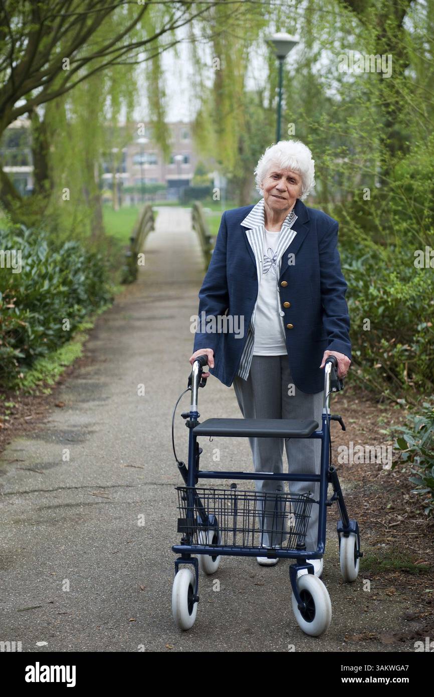 Très vieille dame à l'extérieur marche walker bleu Banque D'Images