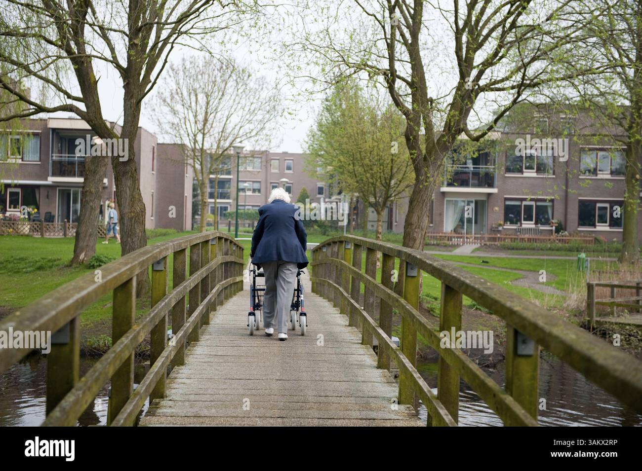 Femme âgée avec marcheur sur le pont Banque D'Images