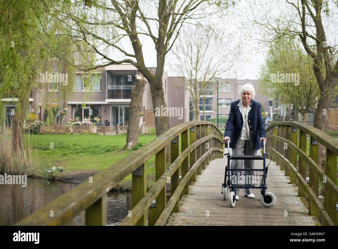 Très vieille dame avec walker bleu par sa maison Banque D'Images