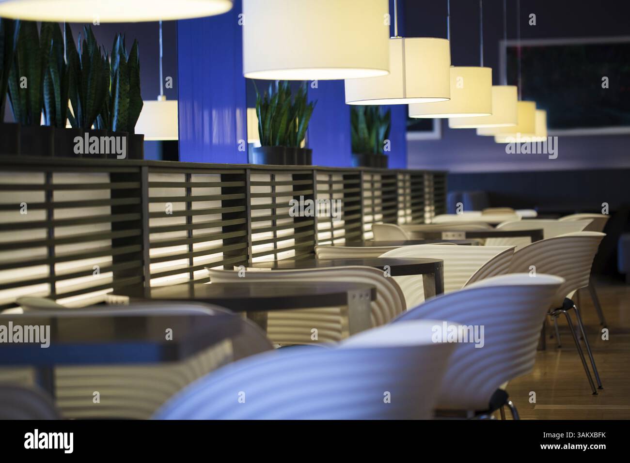Restaurant moderne vide intérieur avec chaises, tables et lampes suspendues Banque D'Images
