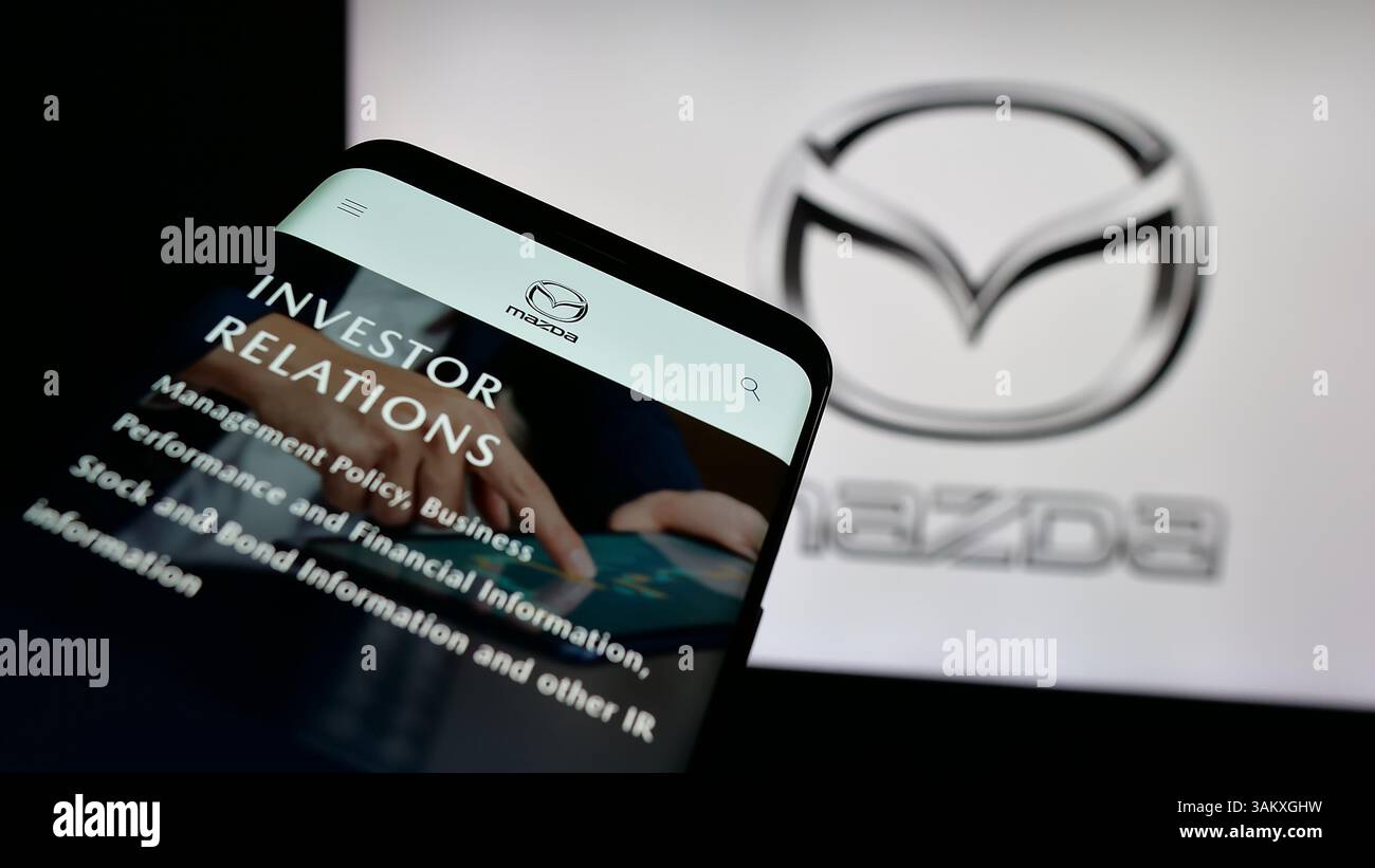 Stuttgart, Allemagne - 11-27-2024, téléphone portable avec le site Web de la société automobile japonaise Mazda Motor Corporation sur l'écran devant le logo. Banque D'Images