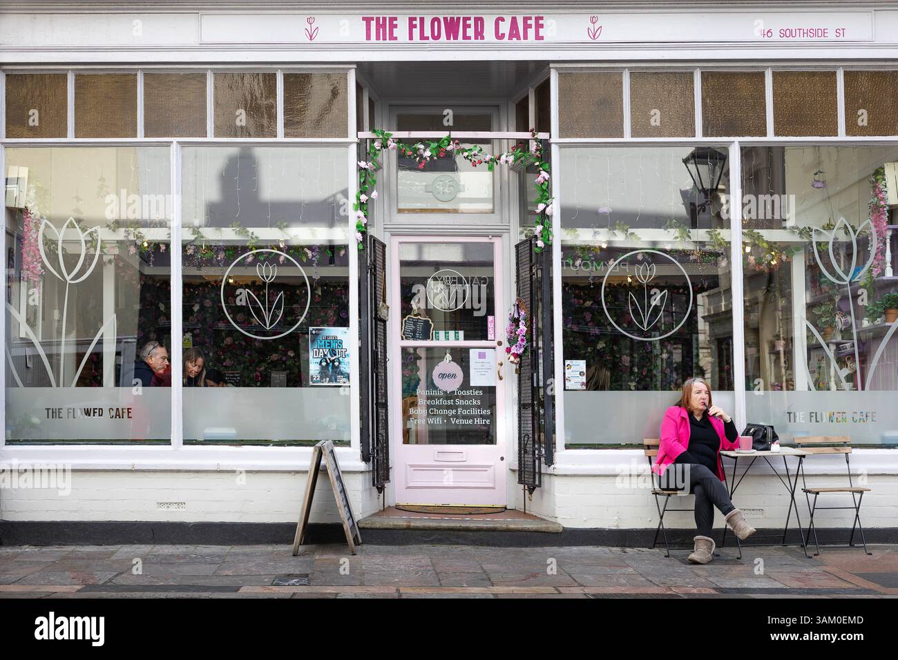 photographie de rue, une femme assise à côté d'un café vapotant Banque D'Images
