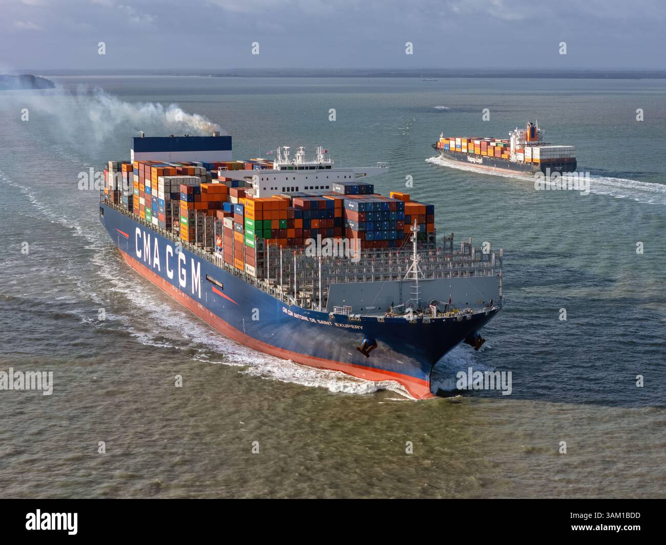 L’Ultra large Container Carrier (ULCC) CMA CGM Antoine de Saint Exupéry passant le porte-conteneurs Hapag-Lloyd Québec Express, en mer. Banque D'Images