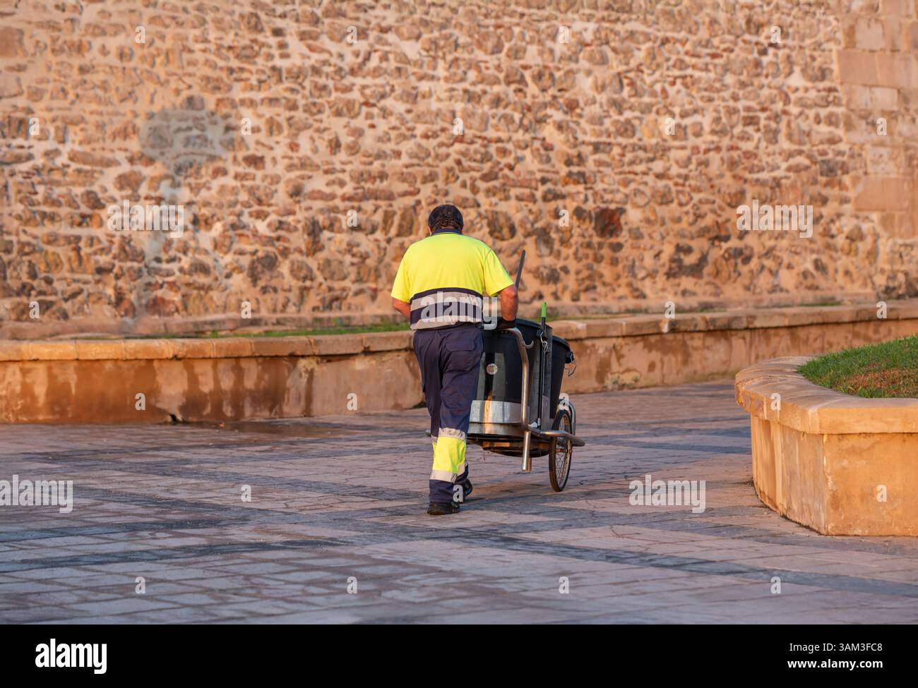 Roquetas de Mar, Almeria, Andalousie, Espagne 12 septiembre 2024 : Un nettoyeur de rue avec un chariot à l'aube. Banque D'Images