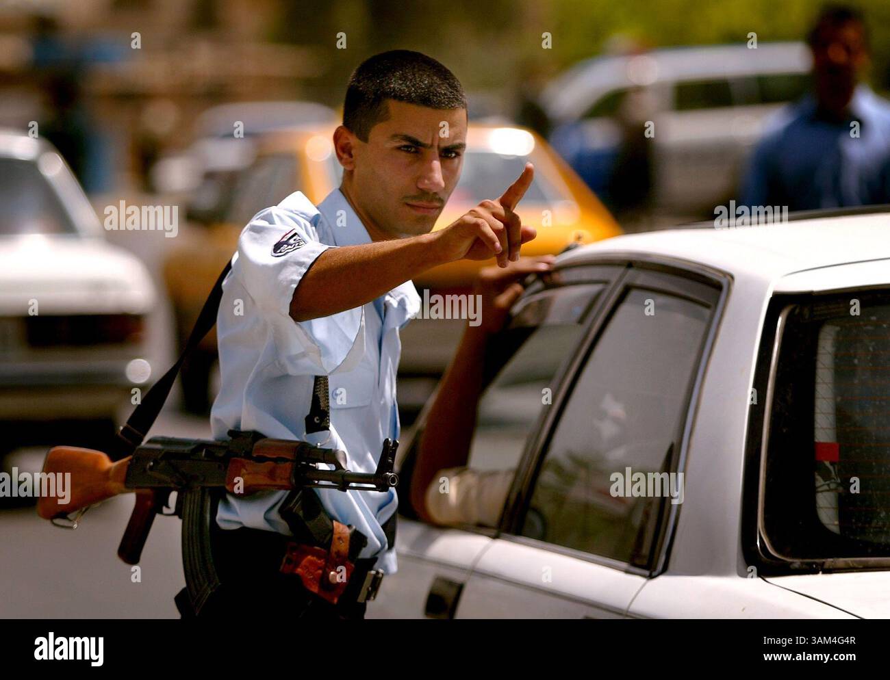 22 juin 2004 - Etats-Unis - KRT STAND ALONE WORLD NEWS PHOTO SLUGGED : USIRAQ KRT PHOTO PAR KHAMPHA BOUAPHANH/FORT WORTH STAR-TELEGRAM (DALLAS OUT) (22 juin) BAGDAD, IRAK -- un policier irakien arrête des véhicules à un poste de contrôle à Bagdad, Irak, le mardi 22 juin 2004. Alors que la date du transfert du pouvoir approche, la police a intensifié ses efforts pour la sécurité. Récemment, ils ont reçu l'ordre de donner des citations pour des infractions au code de la route, une loi qui n'a pas été appliquée depuis le début de la guerre l'année dernière. (nk) 2004 (crédit image : © Khampha Bouaphanh/mct/ZUMAPRESS.com) Banque D'Images