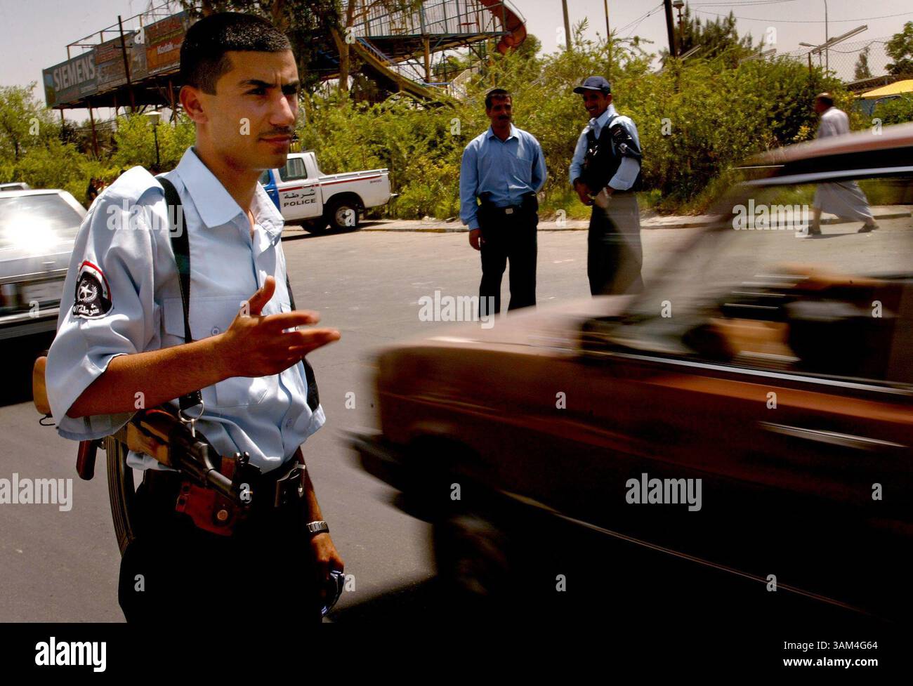 22 juin 2004 - Etats-Unis - KRT STAND ALONE WORLD NEWS PHOTO SLUGGED : USIRAQ KRT PHOTO PAR KHAMPHA BOUAPHANH/FORT WORTH STAR-TELEGRAM (DALLAS OUT) (22 juin) BAGDAD, IRAK -- un policier irakien cherche des violations de véhicules à un poste de contrôle à Bagdad, Irak, le mardi 22 juin 2004. Alors que la date du transfert du pouvoir approche, la police a intensifié ses efforts pour la sécurité. Récemment, ils ont reçu l'ordre de donner des citations pour des infractions au code de la route, une loi qui n'a pas été appliquée depuis le début de la guerre l'année dernière. (nk) 2004 (crédit image : © Khampha Bouaphanh/mct/ZUMAPRESS.com) Banque D'Images