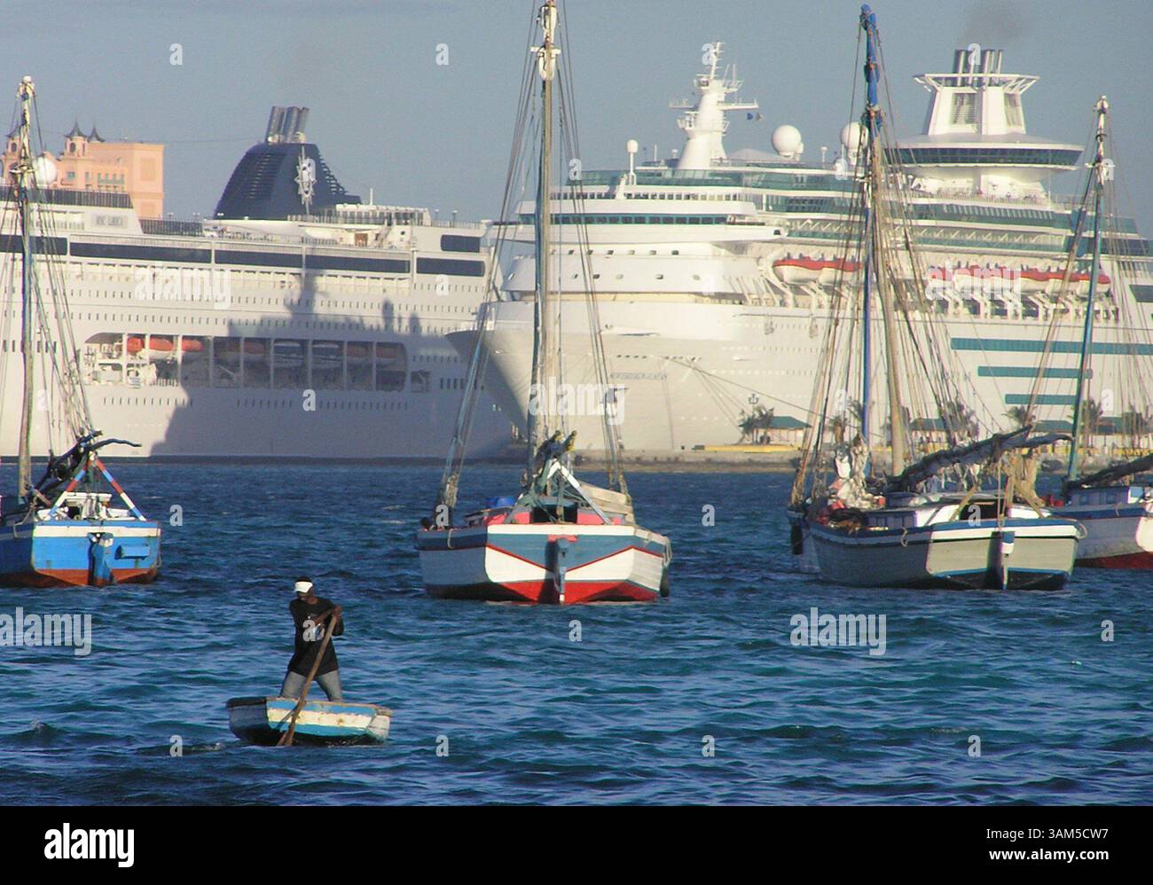 26 janvier 2005 - Etats-Unis - KRT WORLD NEWS STORY SLUGGED : HAITIANSLOOPS KRT PHOTOGRAPHIE PAR JOE MOZINGO/MIAMI HERALD (SOUTH FLORIDA SUN-SENTINEL OUT) (janvier 30) NASSAU, BAHAMAS -- Un marin haïtien se bat contre un vent de face pour se rendre à son sloop, avec des navires de croisière qui se profilent derrière lui. Les sloops faits à la main font un voyage de 500 miles à sens unique d'Haïti aux Bahamas pour vendre du charbon de bois et d'autres marchandises. La plupart n'ont ni radio ni moteurs. (cdm) 2005 (crédit image : © Joe Mozingo/mct/ZUMAPRESS.com) Banque D'Images