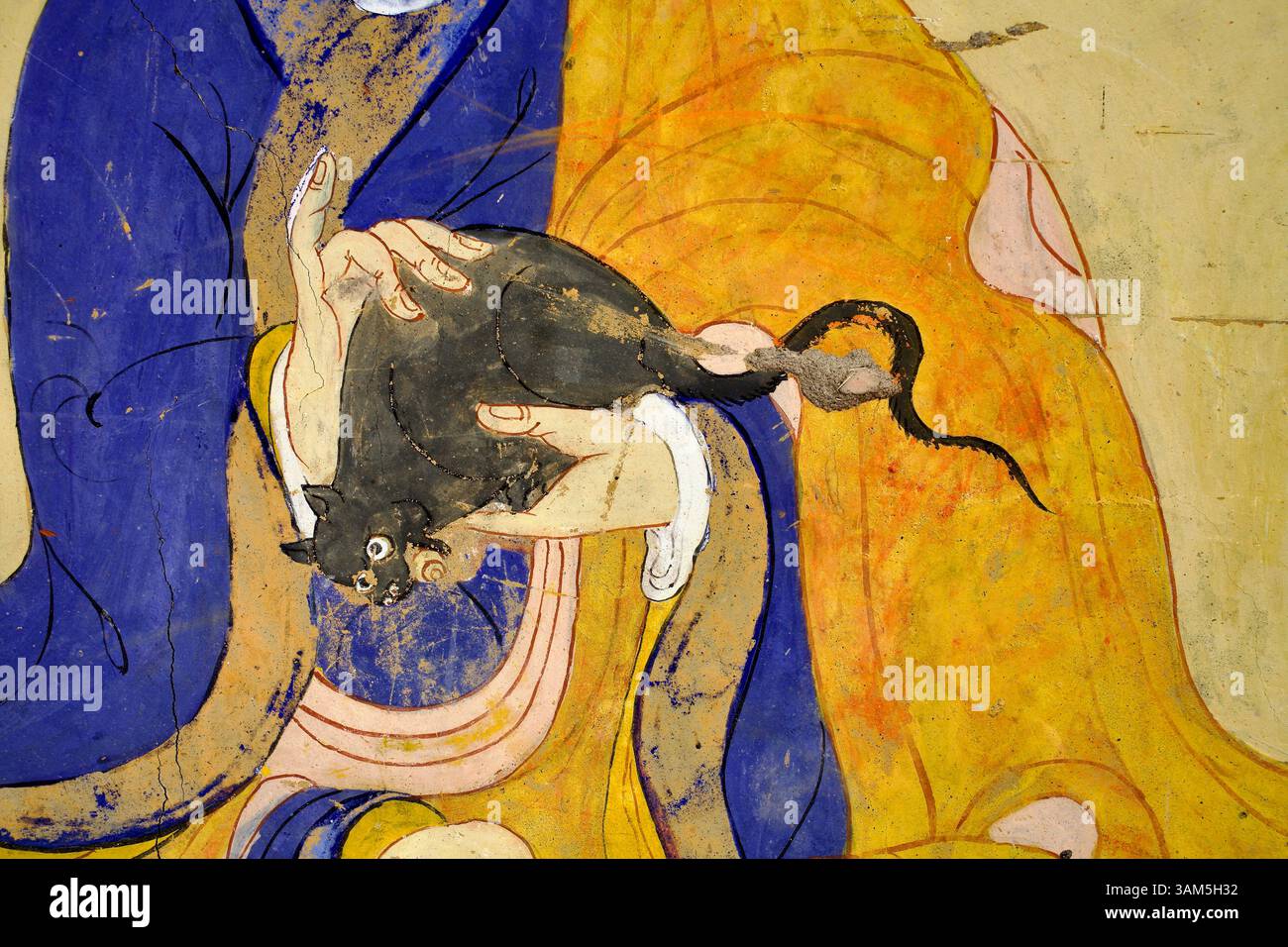 Murale d'un moine tibétain tenant doucement un rat, illustrant la compassion pour tous les êtres sensibles, au monastère Thiksey, Ladakh. Banque D'Images