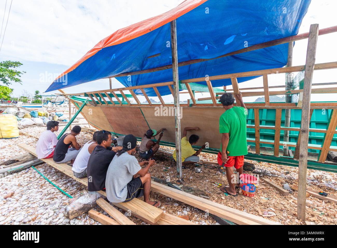Les pêcheurs locaux construisent une banca traditionnelle pour la pêche à Isla Gigantes, Iloilo, Philippines en utilisant du bois et des outils simples dans un village côtier Banque D'Images