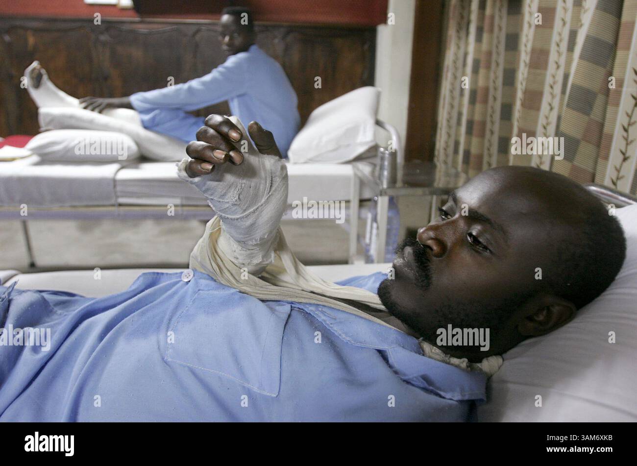 29 novembre 2005 - Etats-Unis - Ernest Nyabose, 30 ans, se remet d'une blessure par balle au bras, à l'hôpital MONUC- mission de maintien de la paix de l'ONU au Congo- à Goma, dans l'est du Congo, le 30 novembre 2005. Nyabose tentait de fuir les FDLR (Force démocratique pour la libération du Rwanda) basées au Congo et de retourner dans son pays d'origine, le Rwanda, lorsqu'il a été abattu par ses camarades soldats. Un autre soldat Jacques Hitimana, 17 ans, en arrière-plan, se remet également d'une blessure par balle à la jambe. (Diversité) (Evelyn Hockstein/KRT) (image crédit : © Evelyn Hockstein/mct/ZUMAPRESS.com) Banque D'Images