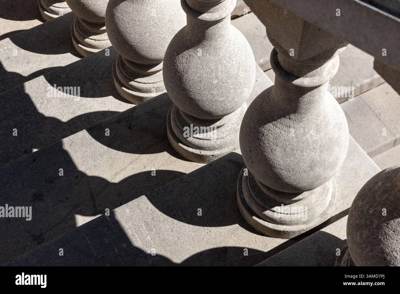 Des balustres en pierre bordent un escalier, projetant des ombres géométriques complexes sous la lumière du soleil, mettant en valeur un design architectural classique. Les ombres créent de la dynamique Banque D'Images
