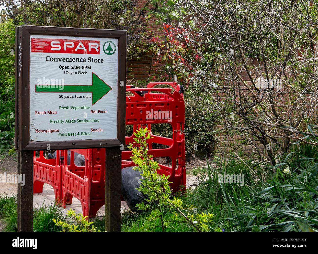 Panneau extérieur dirigeant vers un dépanneur Spar sur le chemin de halage à la colline Caen écluses Devizes entouré de plantes vertes avec des barrières rouges derrière Banque D'Images